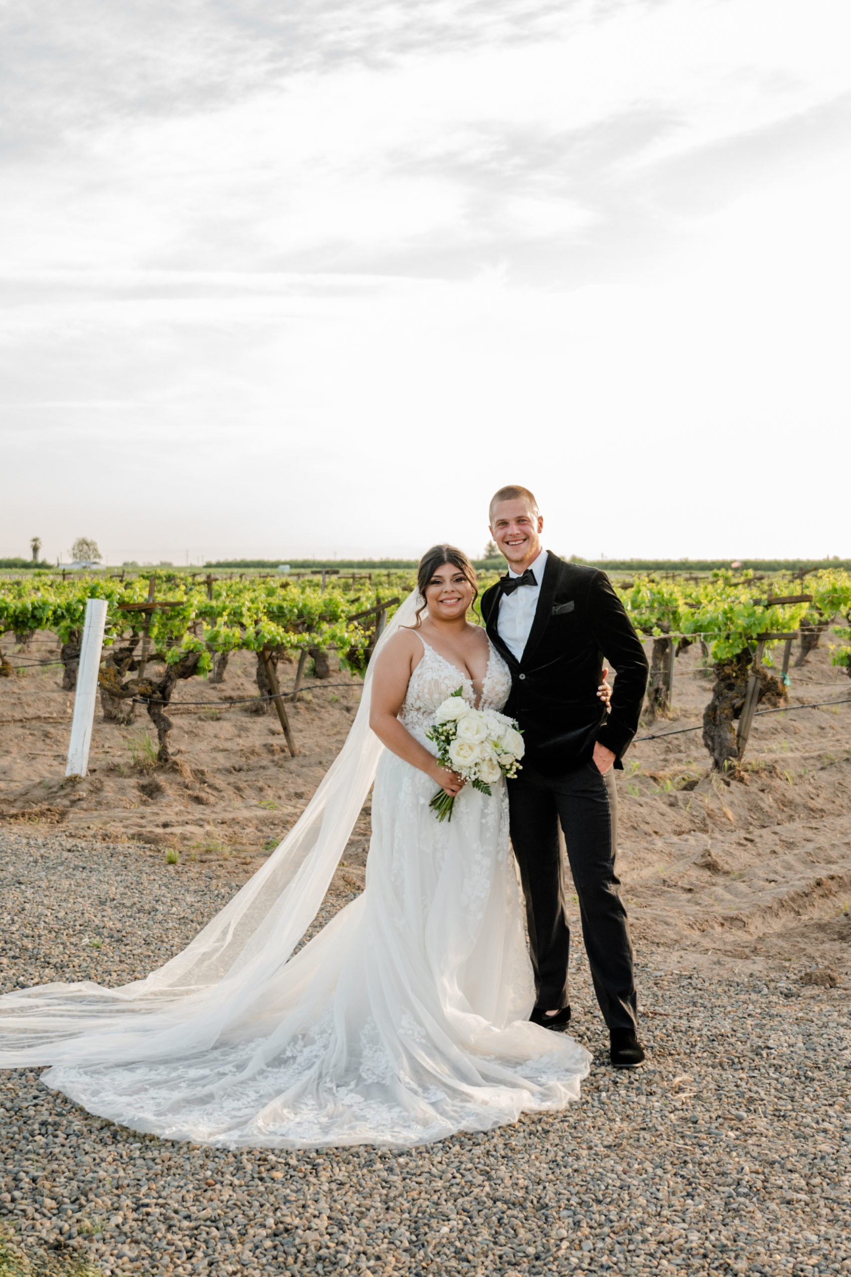 "Elegant bride and groom saying I do in front of lush greenery at Evanelle Vineyards, the perfect setting for a dream wedding.